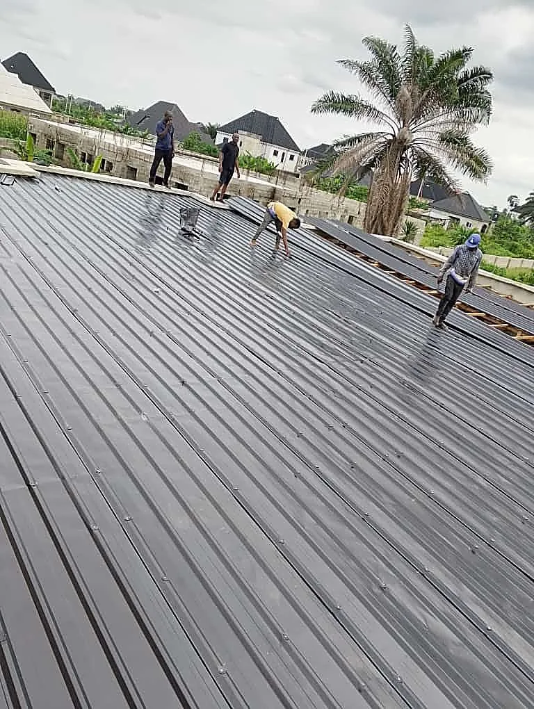 Crew laying corrugated aluminium sheet